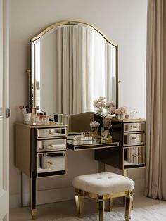 a dressing table with a stool and mirror