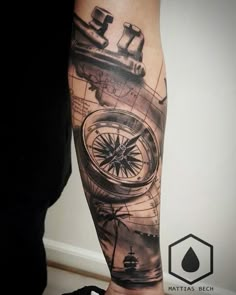 a man's arm with a compass and ship on it