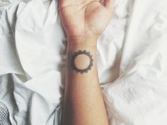 a woman's arm with a small tattoo on it, and a circle in the middle