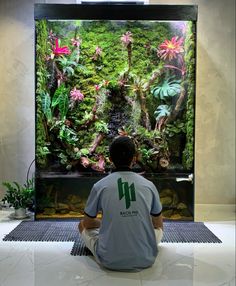 a man sitting in front of a large aquarium