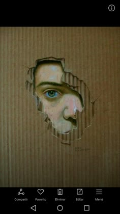 a man's face is seen through a hole in a cardboard box