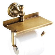 a gold toilet paper holder with a roll of toilet paper on it and a brass faucet