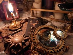 an assortment of antique items on display in a room with candles and other things around it