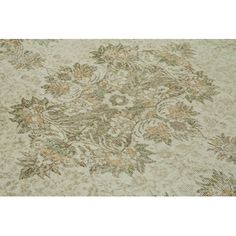 an area rug with flowers and leaves on the ground, in beige tones that are very soft