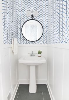 a white sink sitting under a mirror in a bathroom