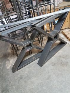 several metal tables and chairs in a warehouse