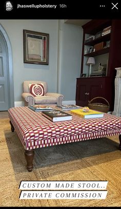 a living room with a couch, chair and coffee table in front of a bookcase