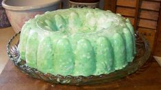 a green cake sitting on top of a glass plate