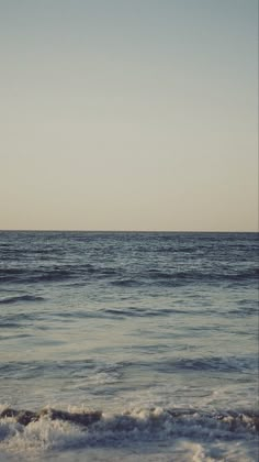 an ocean view with waves coming in to shore