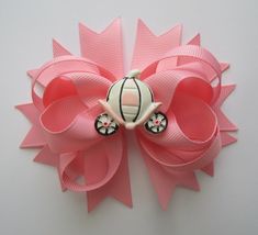 a close up of a pink bow with a car on the front and black wheels