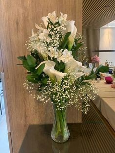 a vase filled with white flowers on top of a table