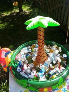 an inflatable palm tree sitting on top of a table filled with bottles and cans