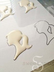 the silhouettes of two women are shown on a sheet of paper with white icing