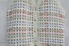 the vest is made out of fabric and has pink, blue, white and green squares on it