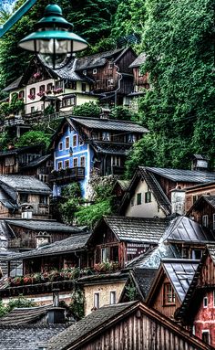 an artistic view of a village in the mountains with lots of trees and houses on it