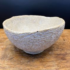 a white bowl sitting on top of a wooden table