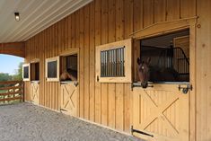 two horses are standing in their stalls at the stable