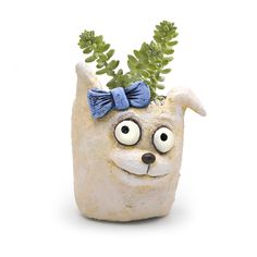 a ceramic planter with a dog face on it's head and green plants in its mouth