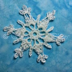 crocheted snowflake on blue fabric