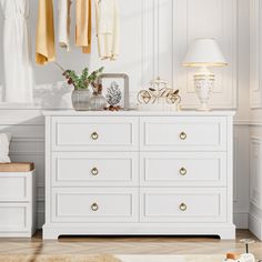 a white dresser with clothes hanging on it