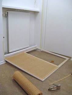 the floor mat is laying on the ground next to an open radiator door