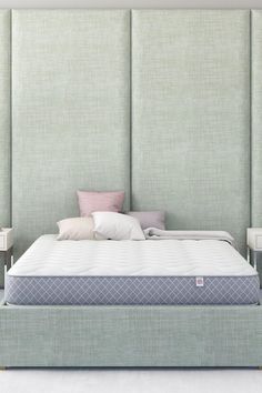 an upholstered bed with two nightstands and pillows on the headboard is shown