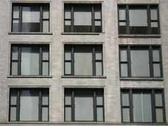 an apartment building with many windows on the side and one sign in front of it