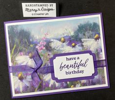 a birthday card with flowers and a purple ribbon