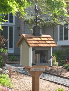 a bird house with a book shelf in the middle of it and trees around it