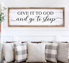 a wooden sign that says give it to god and go to sleep on a couch