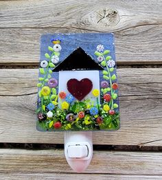 a house shaped light switch cover with flowers and a heart