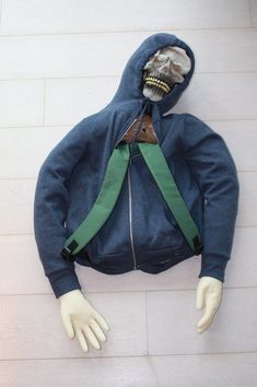 a mannequin wearing a blue jacket and green suspenders with a skull on it