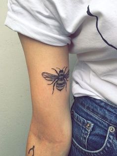 a woman with a bee tattoo on her arm