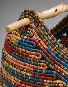 a close up of a colorful basket with a wooden stick sticking out of the top