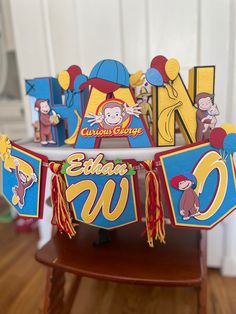 a wooden table topped with paper cutouts and decorations for a children's birthday