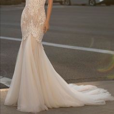 a woman in a wedding dress standing on the street