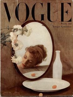 a magazine cover with a woman's face reflected in a mirror and flowers on the table