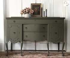 a green dresser with flowers and candles on top