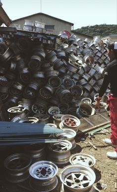 a man standing next to a pile of tires