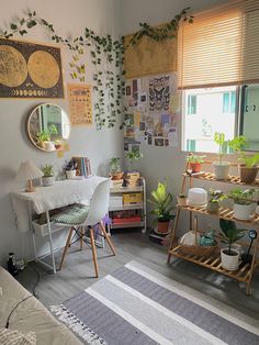 a living room filled with lots of plants next to a table and chair in front of a window