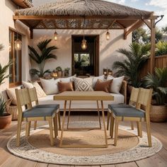 an outdoor living area with couches, tables and plants on the floor in front of a thatched roof