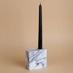 a marble block with a black candle on top