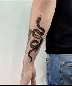 a man's arm with a snake tattoo on it