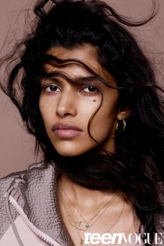 a woman with long black hair and piercings on her face is posing for the camera