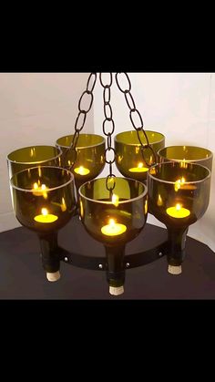 a chandelier with many lit candles hanging from it's chains on a table