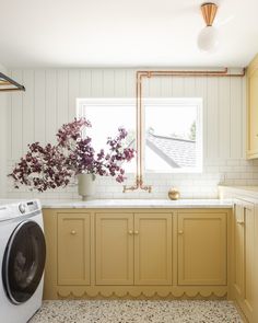 a washer and dryer in a small room with white tile flooring on the walls