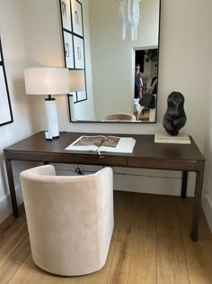 a desk with a mirror and chair in front of it