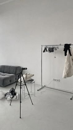 an empty room with clothes hanging on the rack and other items in front of it