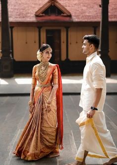 a man and woman standing next to each other in front of a building with a red roof