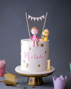 there is a cake that has two people on top and one in the middle with gold stars